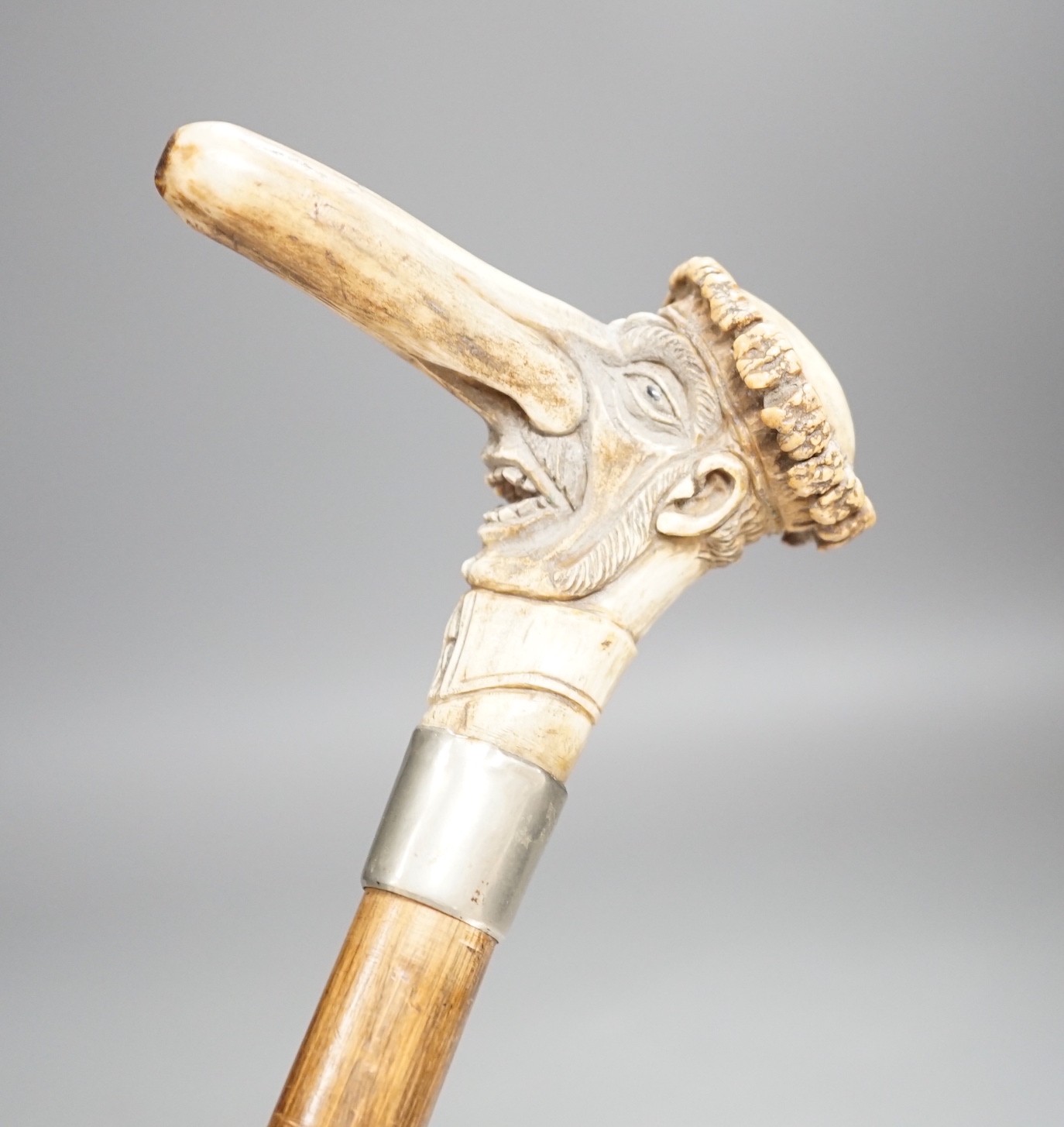 A novelty carved stag horn handled cane, of a large nosed gent, 78cms long